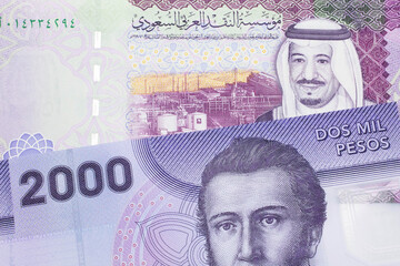 A purple two thousand peso bank note from Chile with A colorful five Saudi riyal bank note close up...