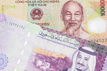 A colorful ten thousand dong note from Vietnam close up in macro with A colorful, five Saudi riyal bank note