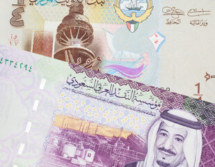 A one quarter dinar from Kuwait close up with a colorful Saudi Arabian five riyal note in macro