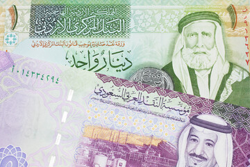 A colorful five Saudi riyal bank note with a one dinar bill from Jordan, close up in macro