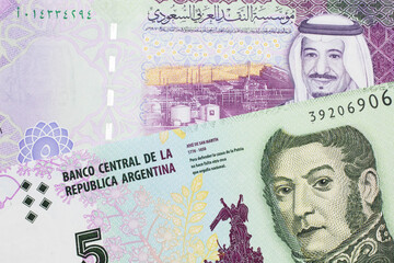 A five peso bill from Argentina, close up in macro with a colorful five riyal bank note from Saudi Arabia