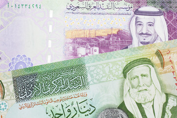 A colorful five Saudi riyal bank note with a one dinar bill from Jordan, close up in macro