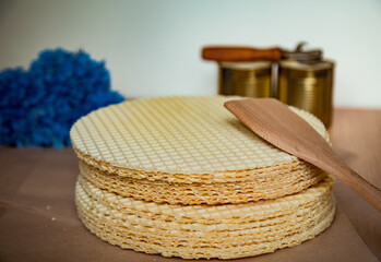 Obraz premium step by step, making a waffle cake, with condensed milk, and decorating with blue flowers