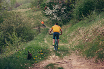 Obraz premium A man riding a bike down a dirt road