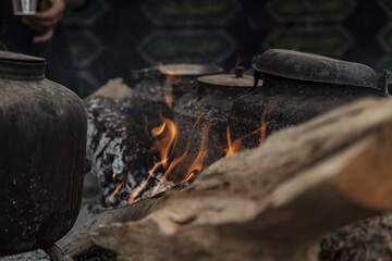 Old black kettles and pots on the fire in a park