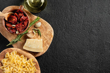 Ingredients for pasting pasta with sun-dried tomatoes and parmesan. Italian Cuisine. Image with copy space - obrazy, fototapety, plakaty