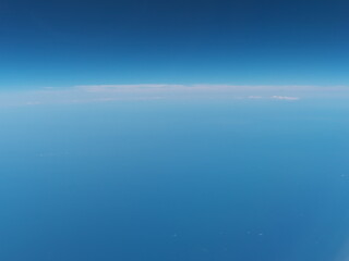 Naklejka na ściany i meble At sea, Japan-June 23, 2020: View of horizon from the window in the airplane 