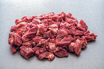 Obraz premium Pieces of raw meat on a grey table.