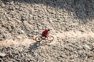 Aerial view of a man cycling on bumpy path
