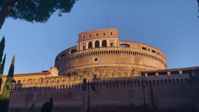 The facade of Castel Sant'Angelo (Castle of the Holy Angel) seen from the park of the Mole Adriana (Parco Adriano) at sunset.