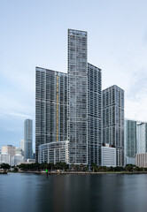Miami, FL/USA - 06/20/2020: Icon Brickell luxury apartment towers during cloudy sunrise.