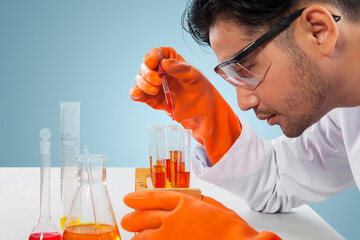 Male researcher analyzing chemical liquid on studio