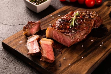 Zelfklevend Fotobehang Fresh grilled meat. Grilled beef steak medium rare on wooden board. Picanha. Top view. © paulovilela