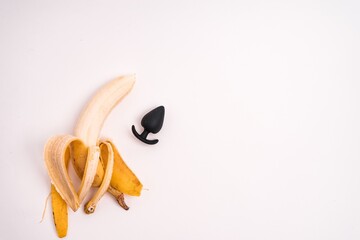 Anal plug and a peeled banana isolated on a white background