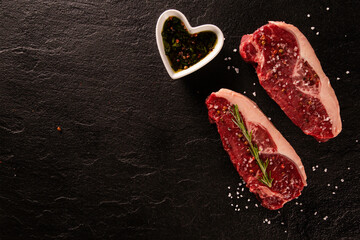 Two raw picanha steaks with spices on a dark background - Powered by Adobe
