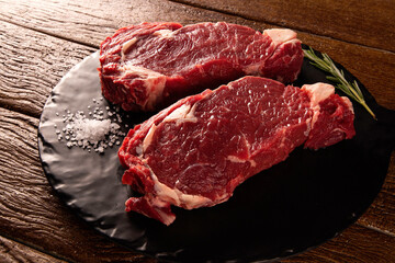 Raw ancho meat  for cooking on dark cutting board. Wooden background.