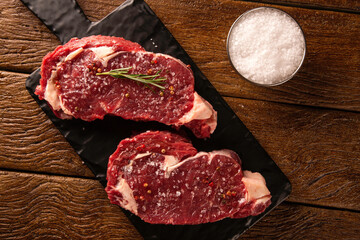 Raw ancho meat  for cooking on dark cutting board. Wooden background.