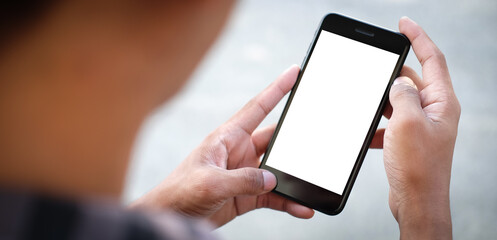 Mock up smartphone of hand holding black mobile phone with blank white screen.