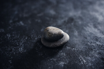 meditation concept, stacked pebbles on dark background with minimalist composition