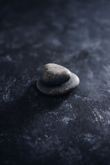 Fototapeta na wymiar meditation concept, stacked pebbles on dark background with minimalist composition