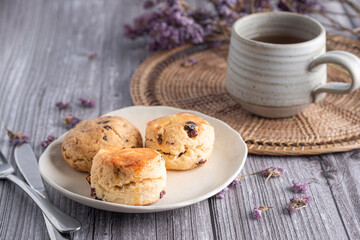 Traditional British scones and cookie with a tea cup and blurred background