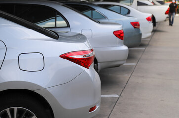 Fototapeta premium Closeup of rear, back side of bronze car with other cars parking in indoor parking area.