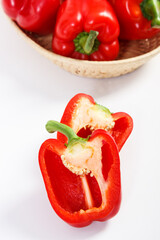 Red peppers with wicker basket on white background, concept of healthy nutrition