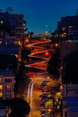 High angle view of illuminated homes on Lombard Street in San Francisco, California at sunset with car light trails - obrazy, fototapety, plakaty