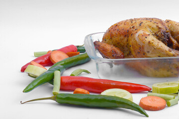 Roasted chicken in glass baking tray with vegetables