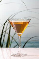 a delicious looking cocktail in a martini glass on a table on an out of focus background. Holiday concept.