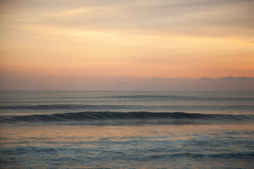 Calming sunset on the beach of  Pantai Lima with isolated glassy ocean wave, Bali Indonesia. 
