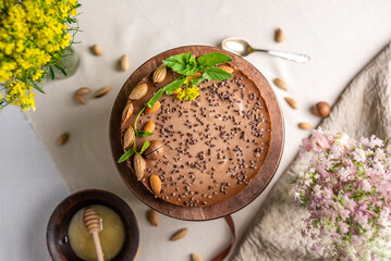 Delicious mousse nut cake decorated with nuts and green leaves. Concept of delicious and healthy desserts