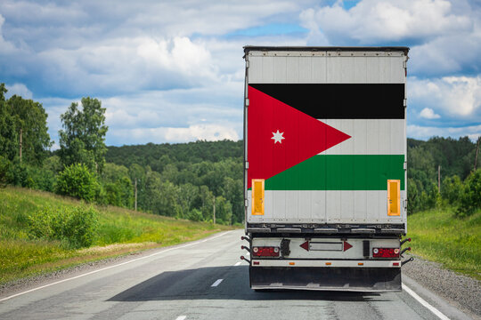 A  truck with the national flag of Jordan depicted on the back door carries goods to another country along the highway. Concept of export-import,transportation, national delivery of goods