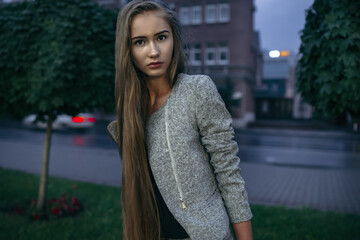 Girl in grey suit posing on the town street