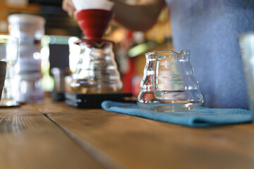 Coffee drip process by pouring hot water from kettle though ground berries bean