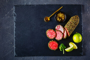 slices of salami served with basil pesto, top view