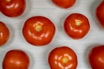Naklejka na ściany i meble Tomatoes on bleached wood. Background on the theme of tomatoes.