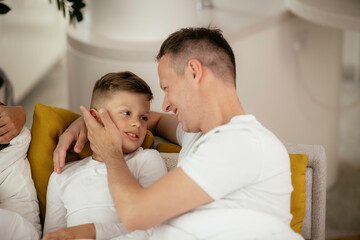 Dad and son are cuddling. Father and son sharing the love at home.	