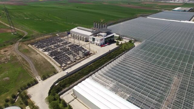 Rotate and move away from the power plant, the moving away reveals a large greenhouse.