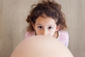 Overhead view of young girl kissing her pregnant mother's belly