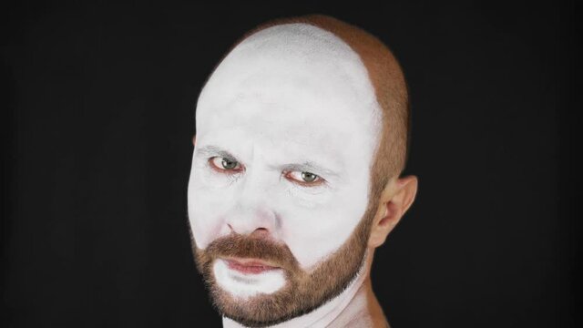 A mime man in a white mask depicts emotions. Man on a black background. High quality 4k footage