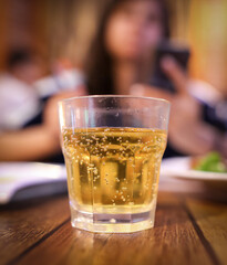 A glass glass with a drink stands on a table