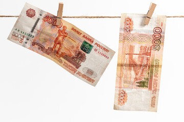 Russian rubles hang on a rope on a white