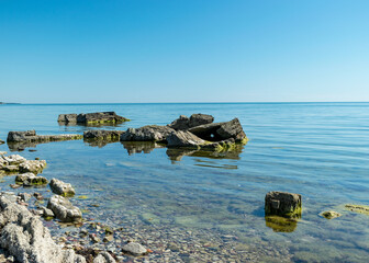 summer landscape with a rocky sea shore, remnants of an old concrete structure in the water, Saaremaa Island, Sorves Peninsula, Estonia