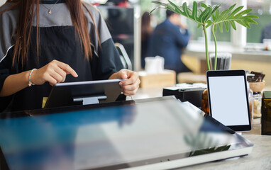 Fototapeta premium Young asian woman use digital tablet to receive orders from customers