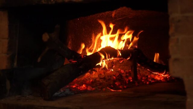Fuoco e ceppo di legno in un forno a legna