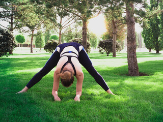 Yoga at park. Caucasian middle-aged woman exercising outdoors