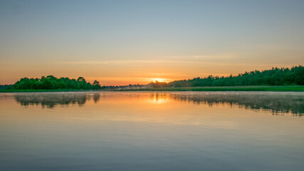 Foggy weather early in the morning on the lake. beautiful wallpapers. a mystical mist vibrates in the lake. summer sunrise