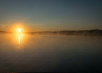 Obraz premium Foggy weather early in the morning on the lake. beautiful wallpapers. a mystical mist vibrates in the lake. summer sunrise