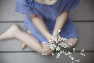 青い服の白い花を持つ女の子